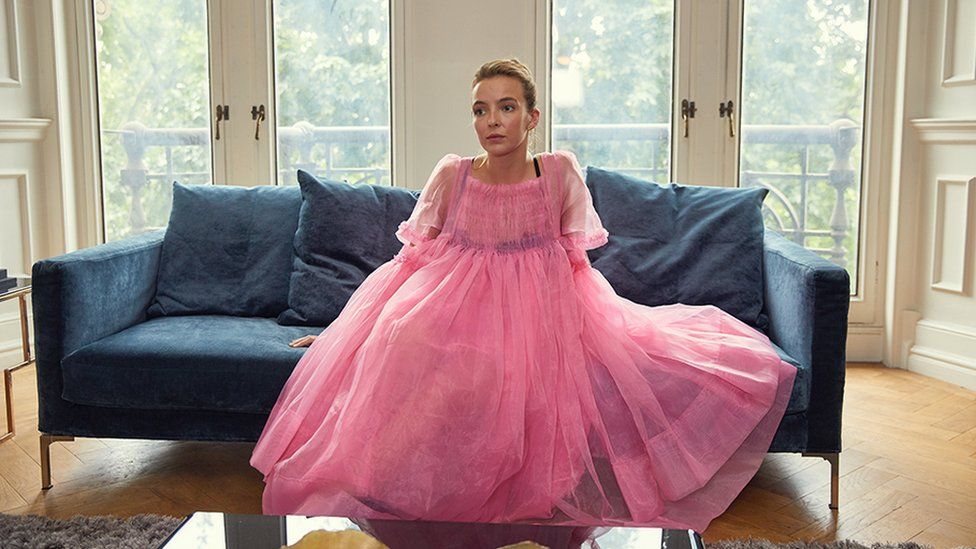 Jodie Comer wearing pink dress as Villanelle in Killing Eve