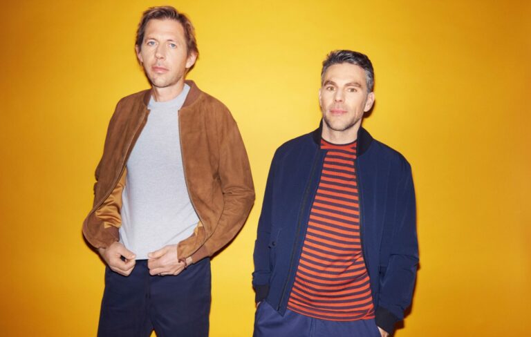 Groove Armada pose side by side against a yellow background