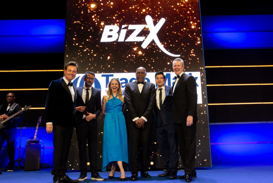 Group of people standing onstage at bizX