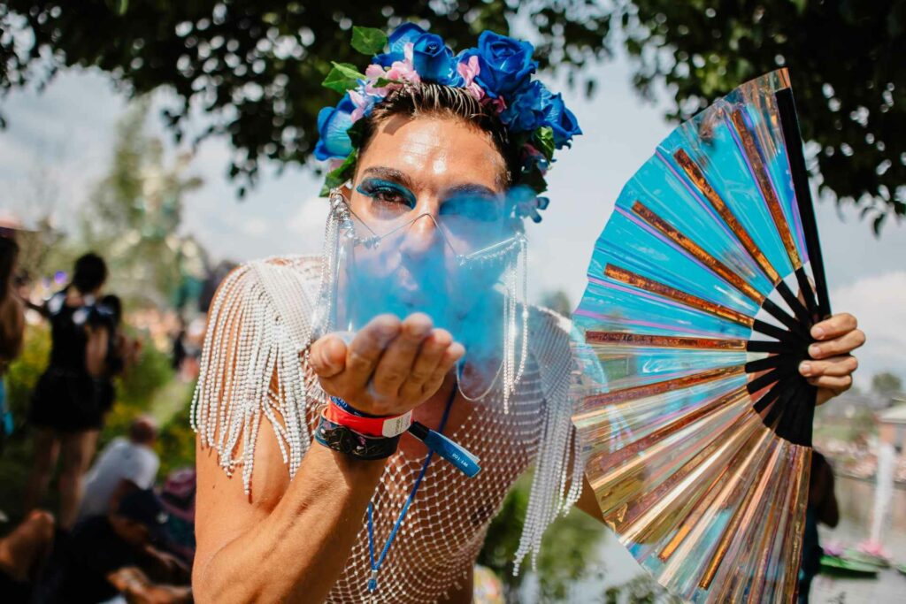 A person blows blue dust into the camera