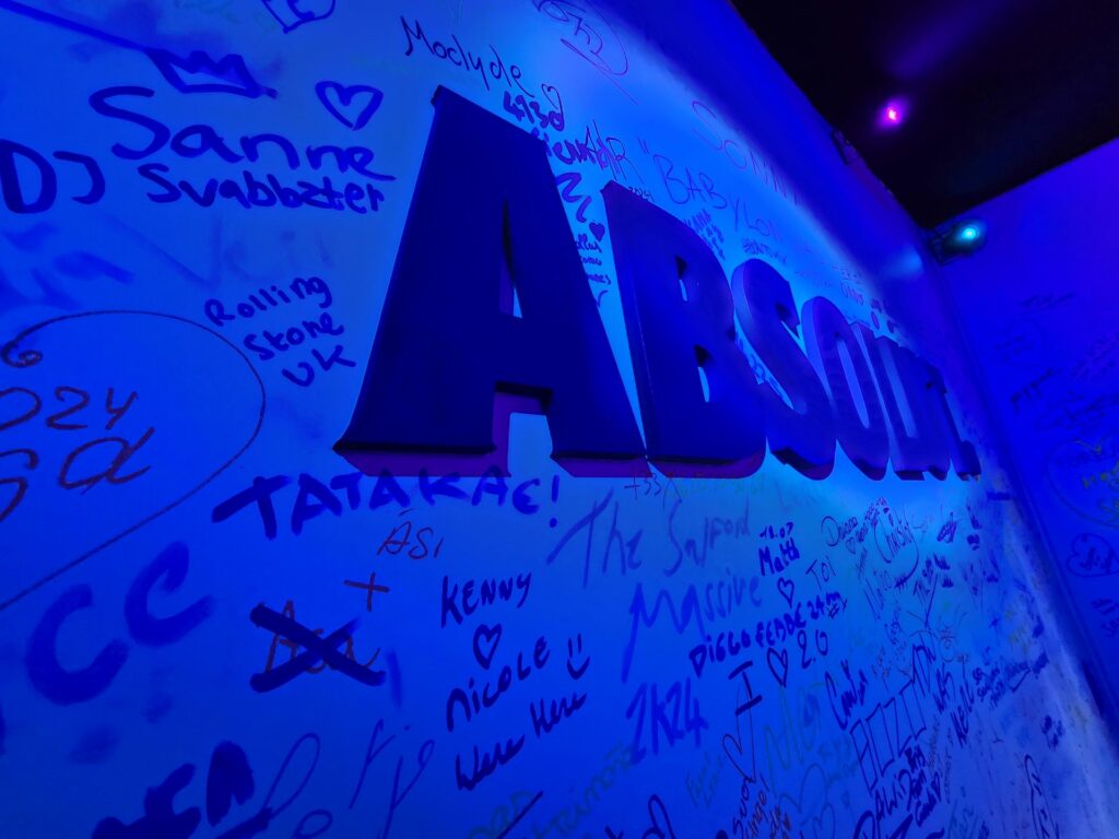 A wall with the Absolut logo on it surrounded by graffiti