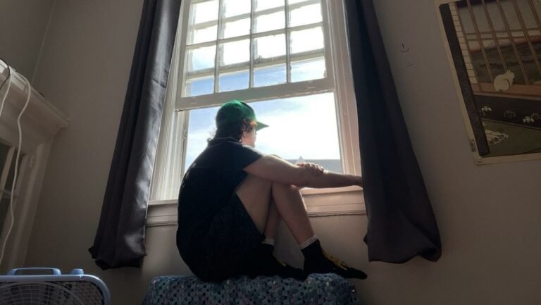A man sitting on a couch looking out of a window
