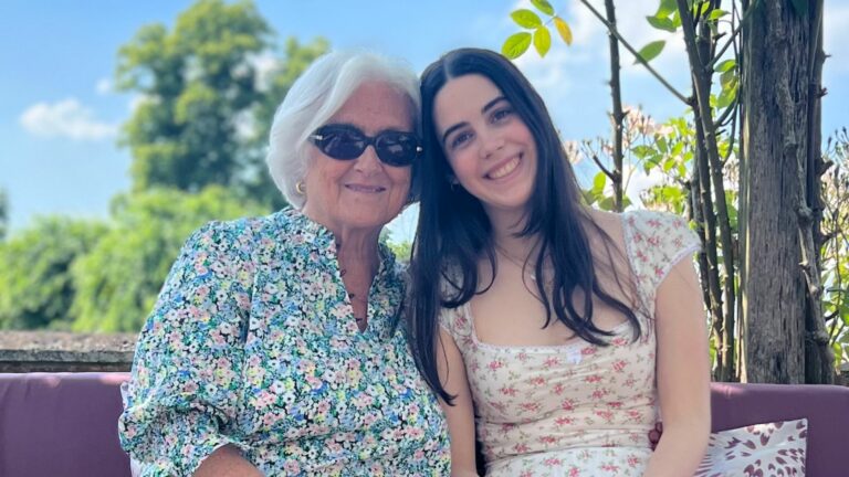 A grandmother and her grand daughter smiling