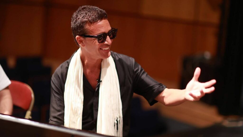 A smiling composer wearing sunglasses