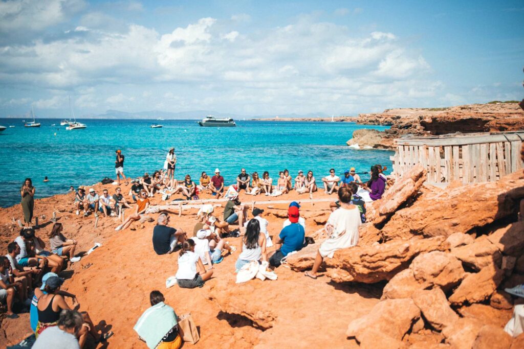 People sitting on a beach with the ocean behind them