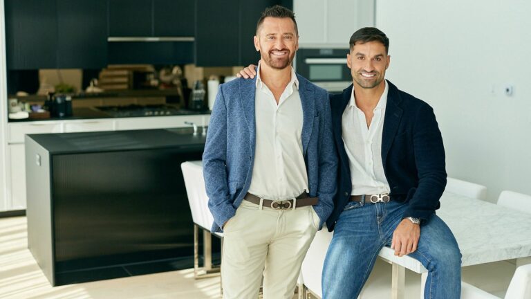 Two men in an apartment hugging