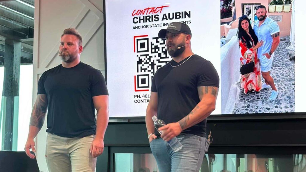 Two men standing in front of a digital display board