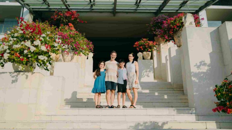 A family standing on the steps of a hotel