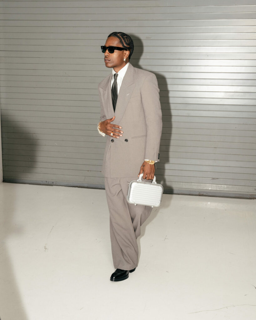 A$AP Rocky poses in black Ray-ban sunglasses in grey suit, white shirt, black tie